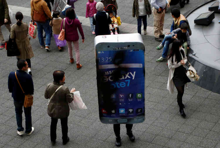 Un participant déguisé en Samsung Galaxy Note 7 défectueux passe parmi les piétons après le défilé de Kawasaki (Japon), le 30 octobre.