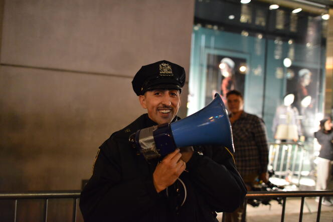A l’aide d’un mégaphone, un agent de la police de New York demande aux passants de ne pas s’arrêter.