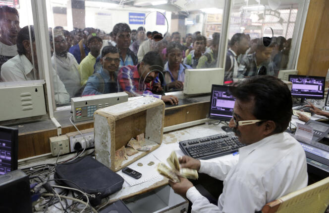 Un employé des chemins de fer indiens compte des billets de 500 roupies à un guichet, l’un des rares endroits qui acceptent encore les grosses coupures, à Allahabad, en Inde, le mercredi 9 novembre.