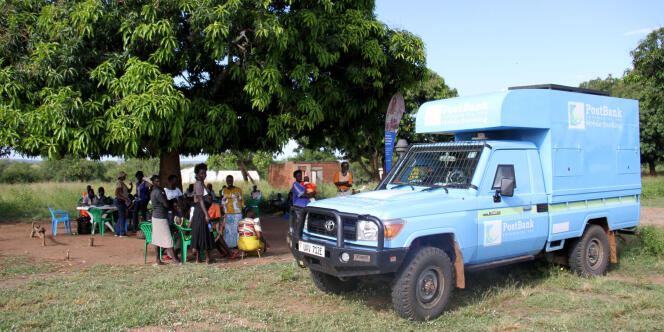 Un petit camion bleu de la Postbank stationne dans le camp de Rhino, en Ouganda, en novembre 2016.