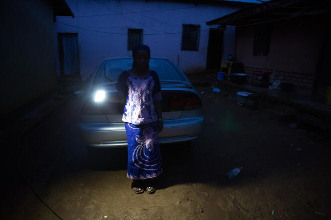 Dans le village de Deng-Deng, une aubergiste se rend à la lampe de poche à son générateur pour le mettre en marche.