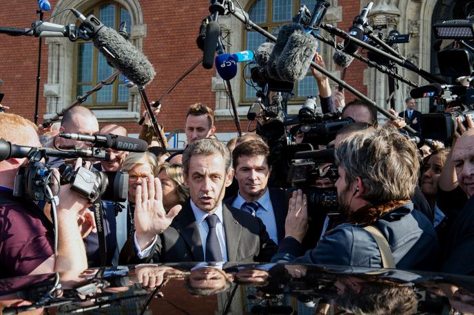 Nicolas Sarkozy (C), entouré de journalistes, alors qu’il quitte la mairie de Calais, le 21 septembre 2016.