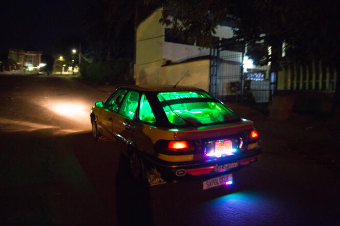 Des guirlandes de LED vertes, rouges et bleues font scintiller le taxi d’Etienne comme un sapin de Noël dans les rues de Yaoundé.