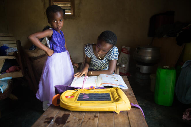 Kouassi et sa petite nièce de cinq ans avec qui elle fait les devoirs.