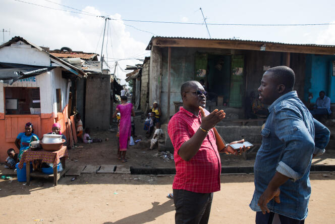 Raoul Loukou Kouassi avec un habitant du quartier du Campement, dans la banlieue d’Abidjan.