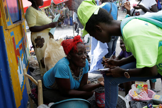 Une marchande de rue discute avec un membre de la campagne de vaccination anti-cholérique, à Cayes, en Haïti, le 8 novembre.