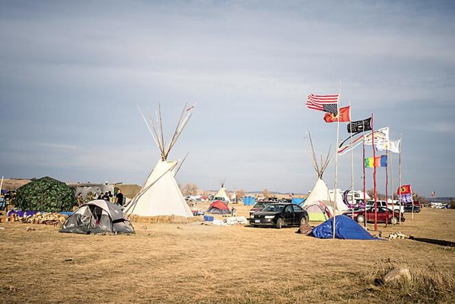 Le campement Oceti Sakowin, sur la réserve de Standing Rock. Des drapeaux indiens y côtoient le drapeau américain. Celui-ci est inversé, en signal de détresse extrême pour cause de menaces sur la vie ou la propriété.