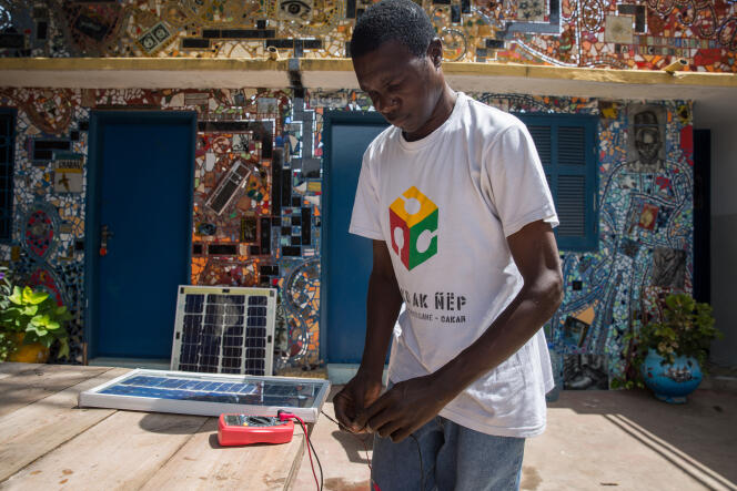 Modou travaille sur son prototype de panneau solaire.