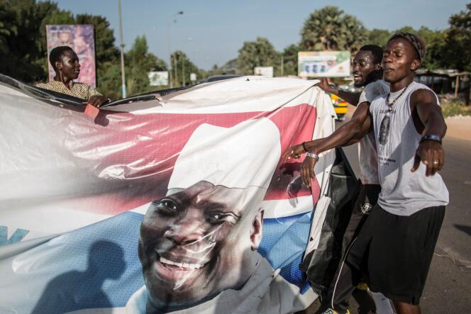 Des partisans du président élu déchirent des affiches de Yahya Jammeh, le 2 décembre, à Serekunda.