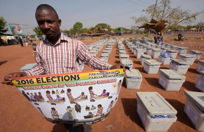 Un responsable de la Commission électorale tient une affiche devant être utilisée dans chaque bureau de vote, à la veille des élections présidentielle et législatives, à Tamale (nord du Ghana), le 6 décembre.