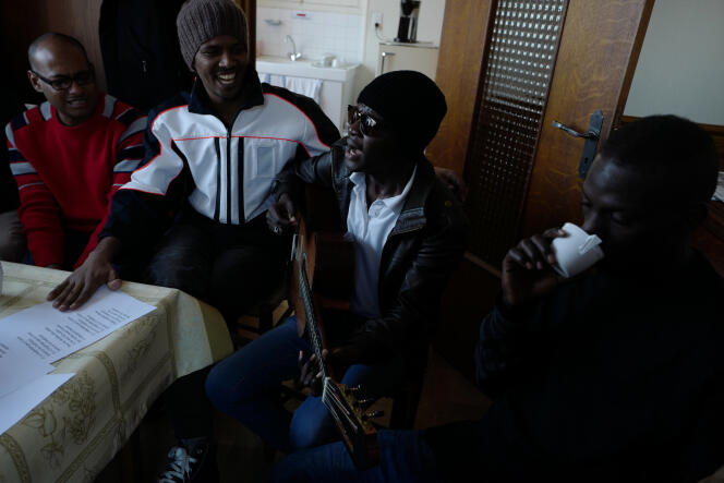 Des demandeurs d'asile soudanais attendent leur tour dans une petite pièce du local du Secours catholique de Cancale, le 1er décembre 2016, lors d'une distribution de vêtements et de produits d'hygiène.