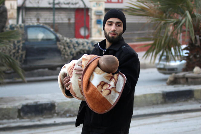 Un homme fuit avec un enfant dans les ruines d’Alep, le 12 décembre 2016.