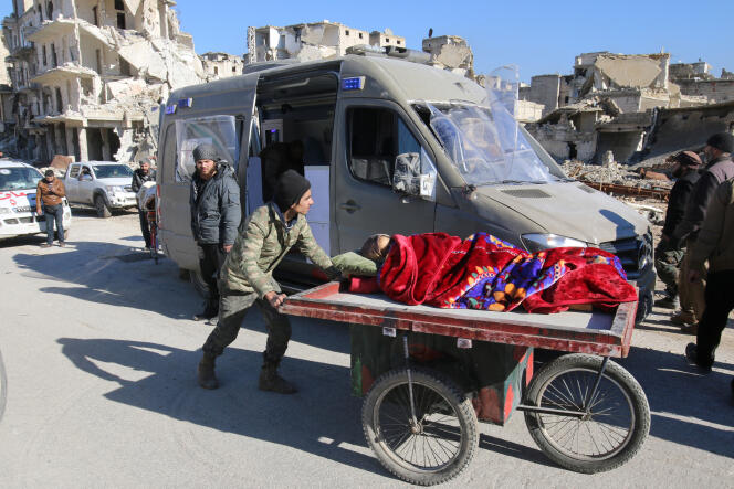 Un homme pousse une femme allongée vers un véhicule chargé d’évacuer les civils d’Alep, jeudi 15 décembre.