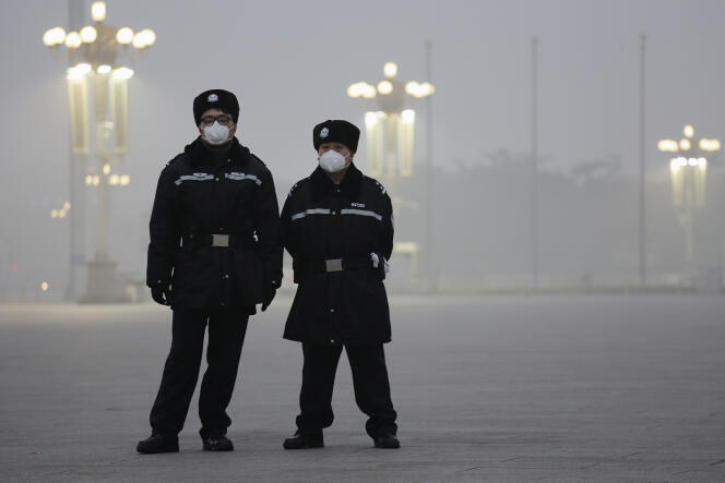 Deux policiers portent un masque antipollution sur la place Tiananmen, le 1er décembre 2015.
