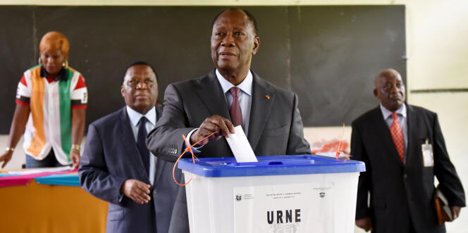 Le président de la Côte d’Ivoire, Alassane Ouattara (c), en train voter en présence du président de la Commission électorale indépendante, Youssouf Bakayoko (à gauche), à Abidjan, le 18 décembre 2016.