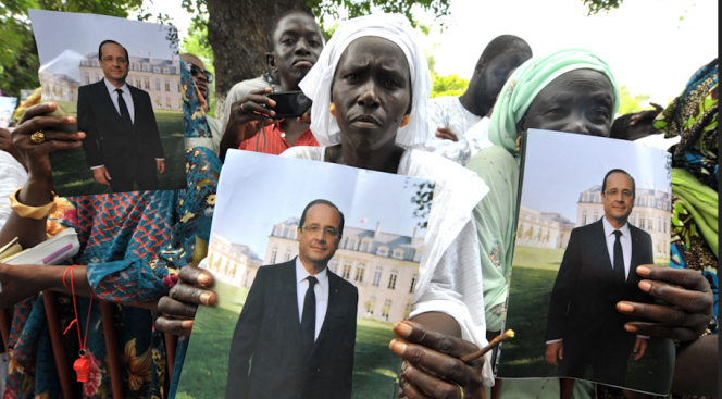 Des Sénégalaises présentent des posters du président français, François Hollande, lors de son voyage à Dakar, le 12 octobre 2012.