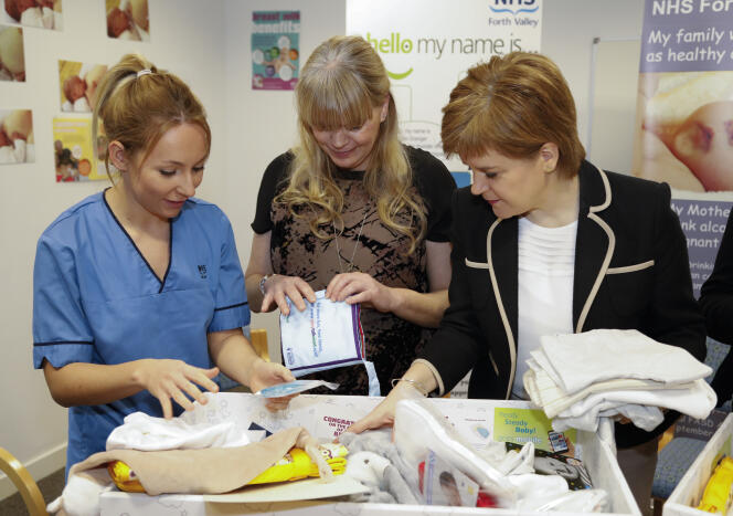 La première ministre écossaise, Nicola Sturgeon, distribue les premières « baby boxes » dans une maternité écossaise, le 1er janvier 2017.