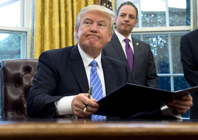 Le président des Etats-Unis, Donald Trump, lundi 23 janvier 2016, dans le bureau Ovale de la Maison Blanche où il signe une série de décrets.