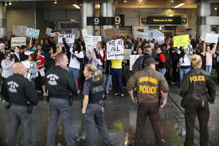 Des manifestants sont réunis à l’aéroport de Miami, où des policiers encadrent leur rassemblement, dimanche 29 janvier.
