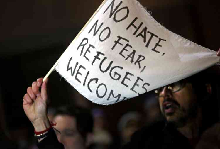 Un drapeau blanc brandi à Brooklyn où est inscrit « Pas de haine, pas de peur, les réfugiés sont les bienvenus »