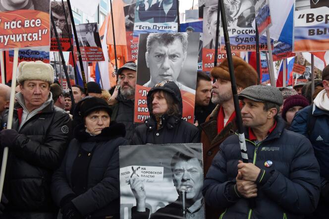 Des partisans de feu l’opposant russe Boris Nemtsov, assassiné il y a deux ans à proximité du Kremlin, brandissent des drapeaux et des affiches lors d’une marche du souvenir, dans le centre de Moscou, le 26 février.