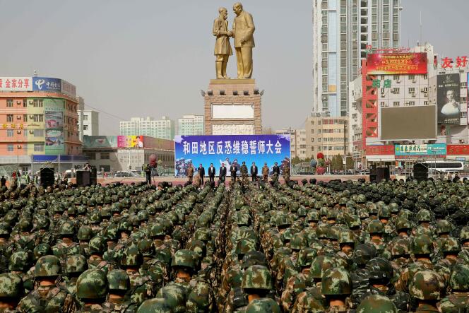 Des policiers militaires chinois prêtent serment contre le terrorisme, à Khotan, au Xinjiang, le 27 février, devant une statue de Mao Zedong et Kurban Tulum, une figure ouïgoure communiste.