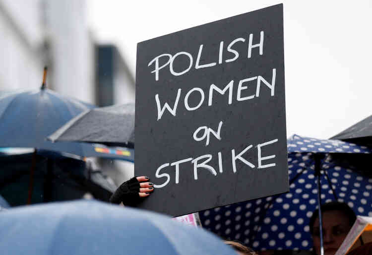 Une femme tient une pancarte lors d’une manifestation pour defendre le droit à l’avortement près des bâtiments abritants les institutions de l’Union européenne, à Bruxelles, en Belgique.
