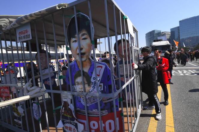 Des militants opposés au gouvernement marchent en direction du palais présidentiel de Séoul, avec une effigie de Park Geun-hye derrière les barreaux, le 10 mars.