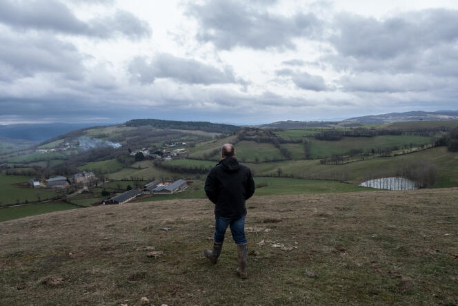Henry Peyrac marche sur une coline de son exploitation bio familiale, près de Cruéjouls en Aveyron, en mars.