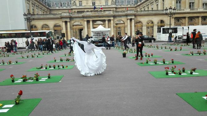 Place du Palais-Royal, à Paris, des artistes de rue déambulent dans les allées, entre les plaques portant le nom des « morts de la rue ».