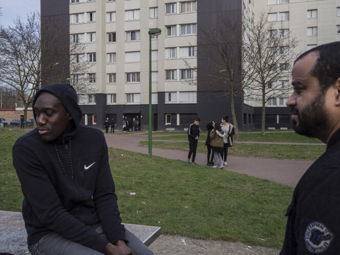 A Aulnay-sous-Bois (Seine-Saint-Denis), fin février. Des anciens du quartier discutent avec quelques jeunes. Au loin, une opération de la BAC dans un hall.