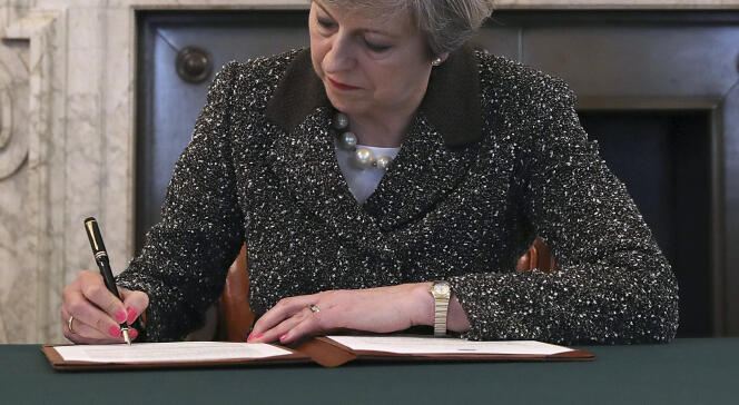 Theresa May signe la lettre par laquelle elle demande au président du Conseil européen la sortie du Royaume-Uni de l’Union européenne, à Londres, le 28 mars.
