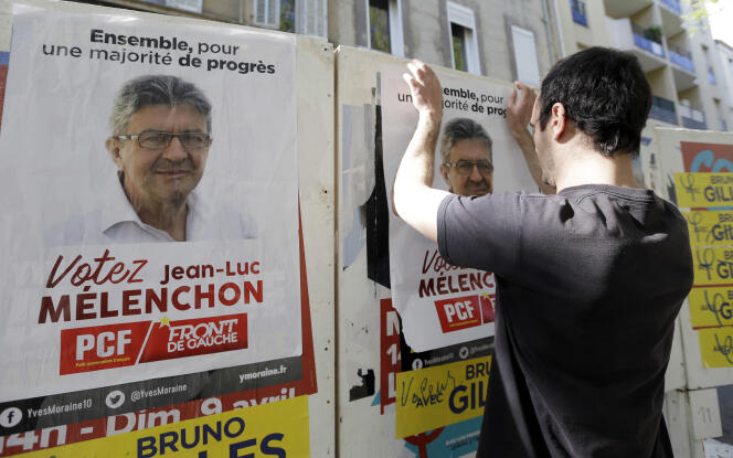 Un partisan de Jean-Luc Mélenchon colle une affiche, le 6 avril à Marseille.