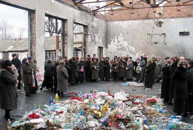 Des rescapés et des proches des victimes se recueillent dans les décombres de l’école de Beslan, le 3 mars 2005. (FILES)