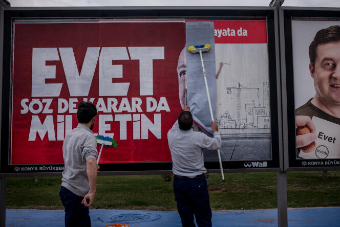 Deux jeunes hommes affichent un poster en faveur du « oui » au référendum turc le 1er avril.