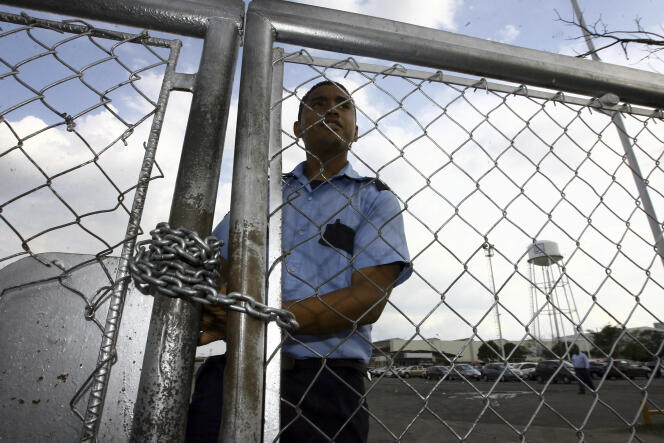 Un agent de sécurité derrière la grille de l’usine General Motors à Valencia au Venezuela, le 19 juin 2009. Le constructeur américain a annoncé le 20 avril 2017 l’arrêt de ses activités dans le pays après que les autorités ont saisi l’usine.