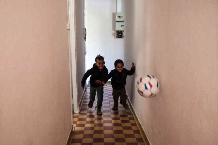 Rafaël (à gauche) et Sam jouent au ballon dans le couloir de leur nouvel appartement.