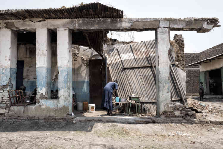 Une femme lave sa vaisselle dans les décombres d’une maison de Malakal.