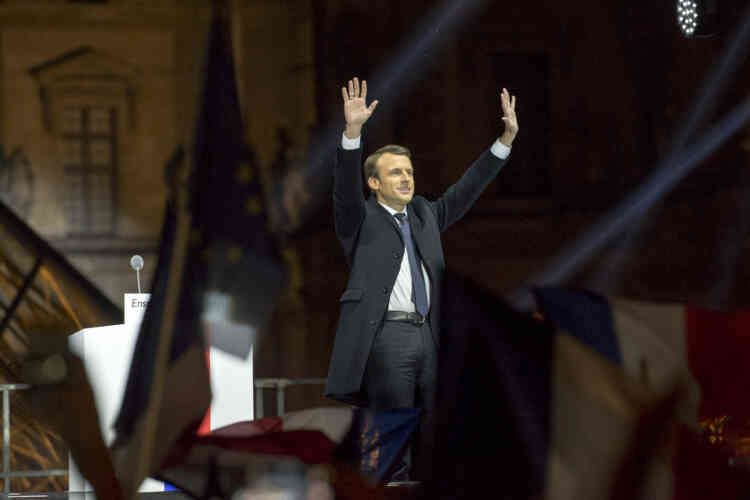 Emmanuel Macron salue le public au pied de la pyramide du Louvre, dimanche 7 mai.