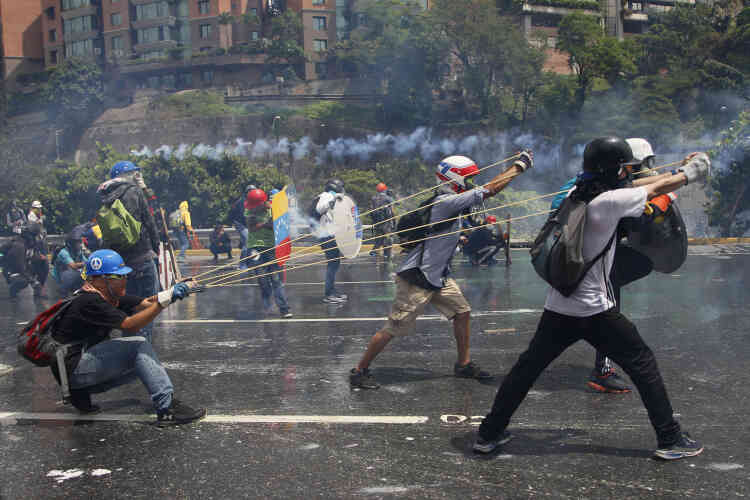 Caracas, le 10 mai. Des manifestants se préparent à lancer sur les forces de l’ordre une bouteille de verre remplie de matières fécales et d’eau (« puputov »), sur certaines figurent des messages : « Pour les prisonniers politiques ! » ou encore « Envoyé avec amour ».