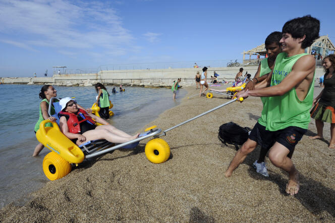 Le service civique fait partie des engagements reconnus par le décret du 11 mai. Ici, des jeunes volontaires en service civique aident une femme handicapée à prendre un bain de mer,  en 2010, à Marseille.