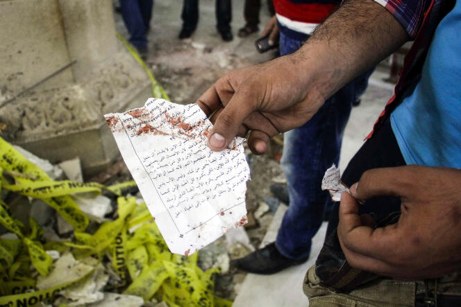 Un Egyptien montre une page de l’évangile de Jean ensanglantée par l’attentat perpétré contre les chrétiens coptes de l’église de Tanta, au nord du Caire, le 9 avril 2017.