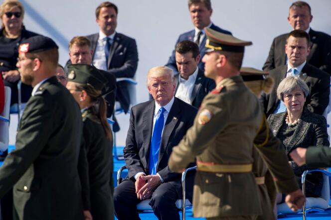 Donald Trump, assis aux côtés de la première ministre britannique Theresa May, lors de la cérémonie au siège de l’OTAN, à Bruxelles, jeudi 25 mai.