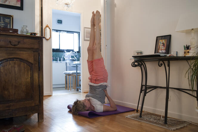 Clotilde Nonnez, professeure de yoga, pratique la chandelle pour désencombrer ses bronches, chez elle, à Paris le 2 juin.