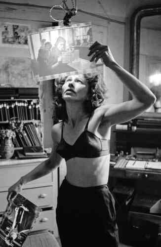 Ata Kandó, photographe hongroise et épouse d’Ed van der Elsken, vérifiant le tirage de la photo de la femme en train de lire, Paris (1953).