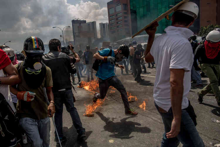 Les altercations entre forces armées et manifestants sont d’une grande violence. Ici un manifestants tente d’éviter un cocktail Molotov, le 10 mai.