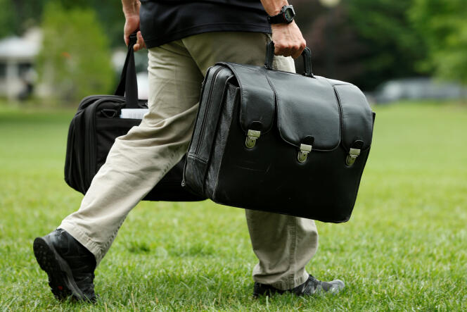Un aide de camp tranporte la valise contenant les codes nucléaires, à la Maison Blanche, le 17 juin.