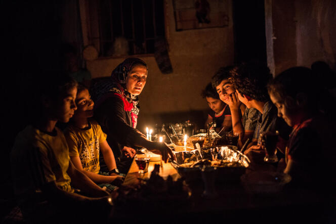 Rupture du jeûne dans une famille obligée de s’éclairer à la bougie, à Gaza, le 15 juin.