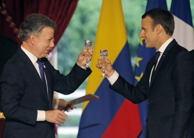 Le président colombien Juan Manuel Santos trinque avec le président français Emmanuel Macron lors d’un dîner officiel à l’Elysée à Paris, le 21 juin.