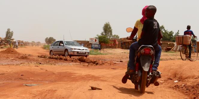 A Tampouy, dans le nord-ouest de Ouagadougou, motards et automobilistes attendent le goudronnage de la route principale, difficilement praticable.
